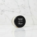 A jar of Baxter of California Cream Pomade, Light Mud / Soft Finish, featuring a black lid with white text and a clear container showing the off-white cream product inside, set against a plain white background.