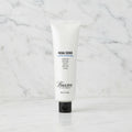 A white squeeze tube of Baxter by Salvador Facial Scrub with a black cap, centered on a plain white background.