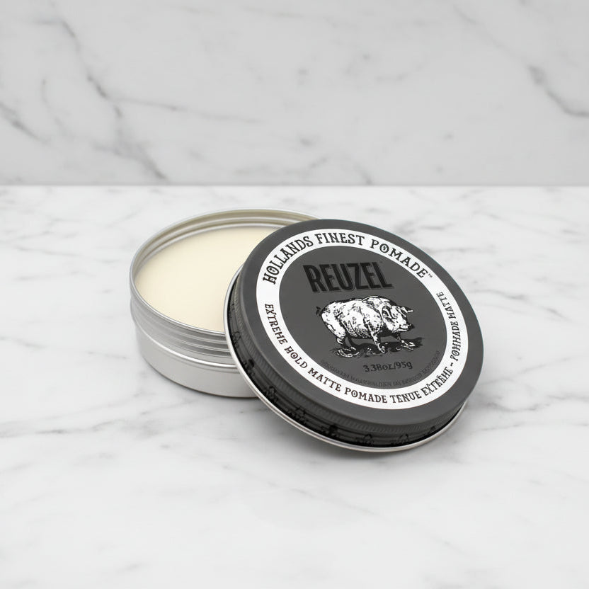 Reuzel pomade tin with open lid on a white background