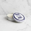 Reuzel pomade tin with blue label on a white background