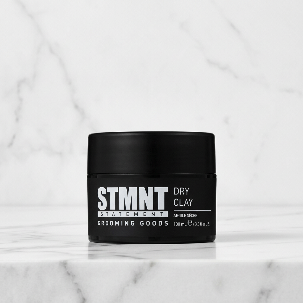 STMNT Dry Styling Clay on white marble with subtle grey veining