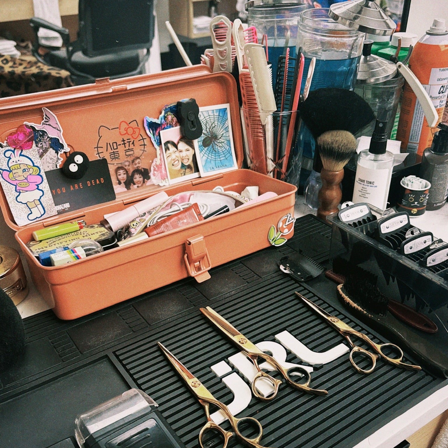 Open orange toolbox with various barber items on a table